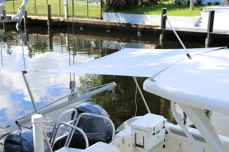 Slide: The Image of 2021 World Cat 255 DC boat with sunshade, docked by a calm waterfront. - 36