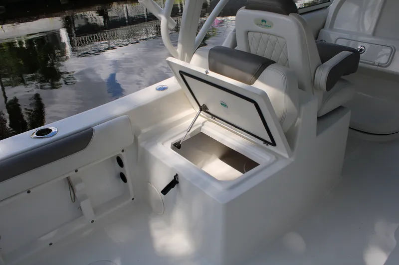 Slide: The Image of 2021 World Cat 255 DC boat interior with open storage compartment and cushioned seating. - 26