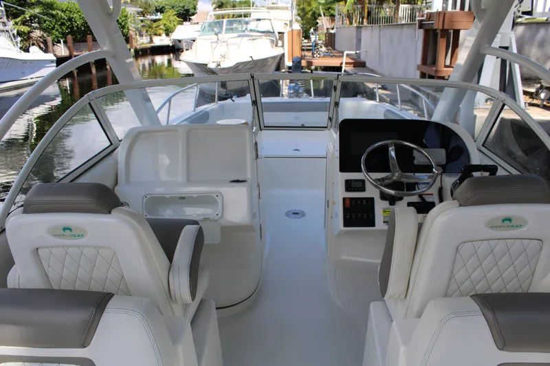 Slide: The Image of 2021 World Cat 255 DC boat interior with steering wheel and seating. - 21