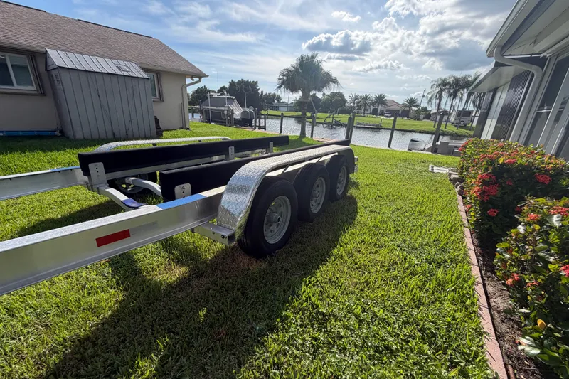 Slide: The Image of 2024 Sardine Marine 34 trailer on grassy lawn near waterfront homes. - 40