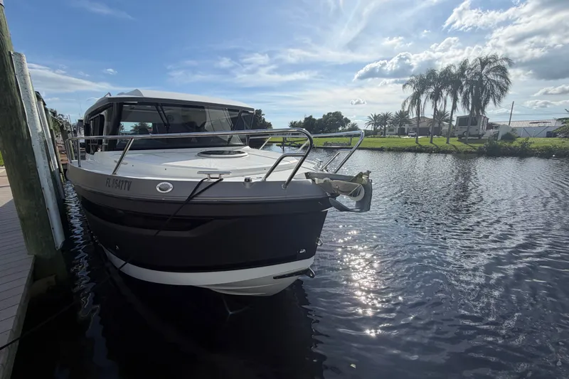 Slide: The Image of 2024 Sardine Marine 34 boat docked on a sunny day by a palm-lined canal. - 39