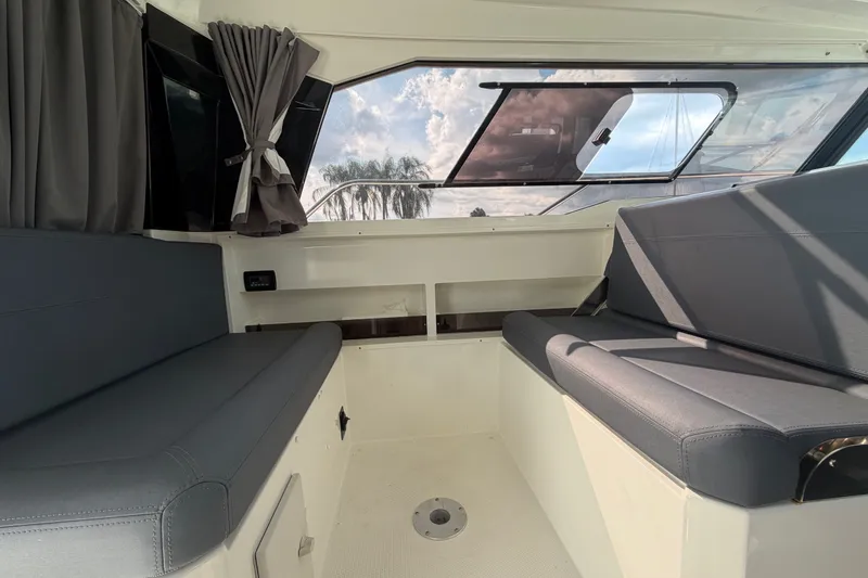 Slide: The Image of Interior of 2024 Sardine Marine 34 boat with gray seating and large windows. - 14