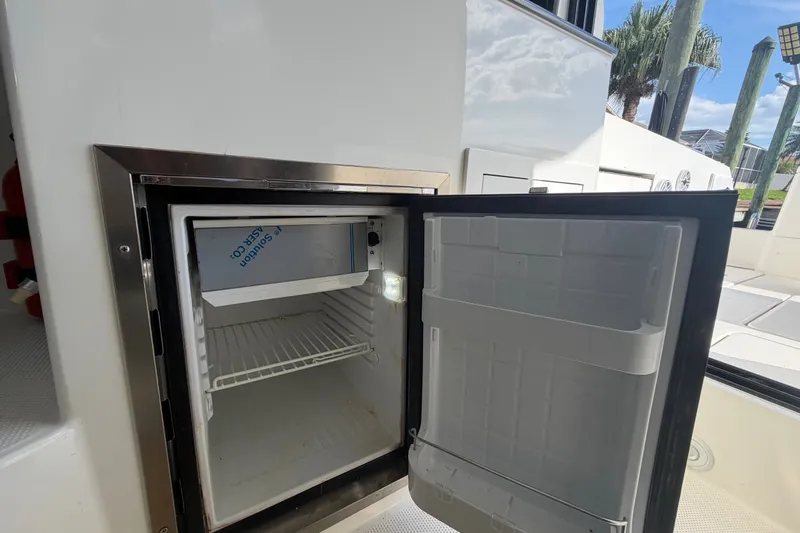 Slide: The Image of Open refrigerator on 2024 Sardine Marine 34 boat, showcasing interior storage space. - 26