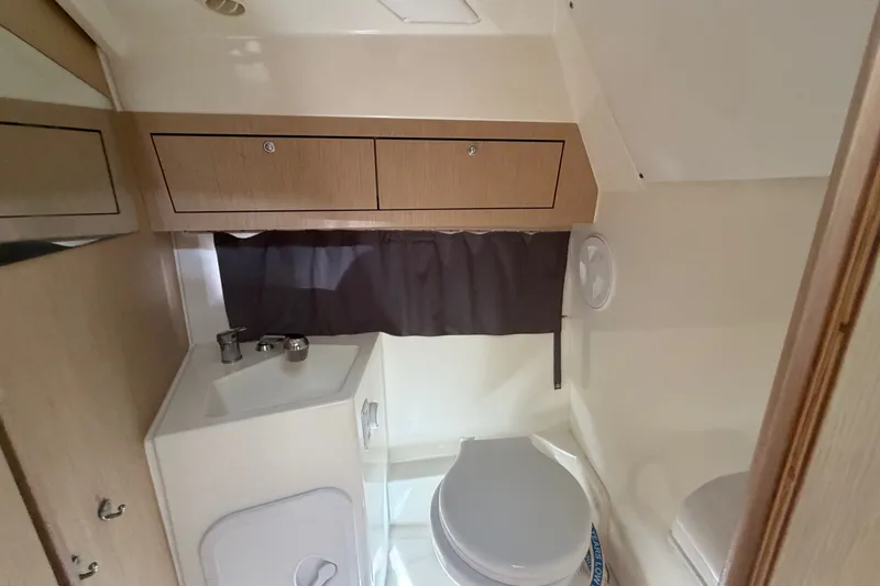 Slide: The Image of 2024 Sardine Marine 34 boat bathroom with sink, toilet, and storage cabinets. - 33