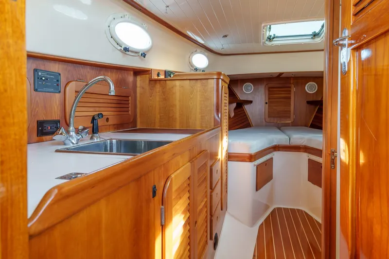 Slide: The Image of Interior of 2001 Hinckley Picnic Boat 36 EP with wooden cabinetry and cozy sleeping area. - 17