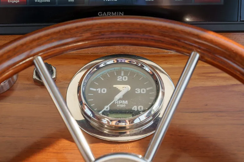 Slide: The Image of Hinckley Picnic Boat 36 EP 2001 dashboard with wooden steering wheel and RPM gauge. - 15