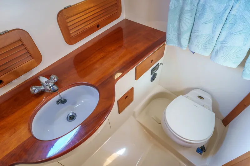 Slide: The Image of Hinckley Picnic Boat 36 EP 2001 bathroom with wooden countertop, sink, and toilet. - 19