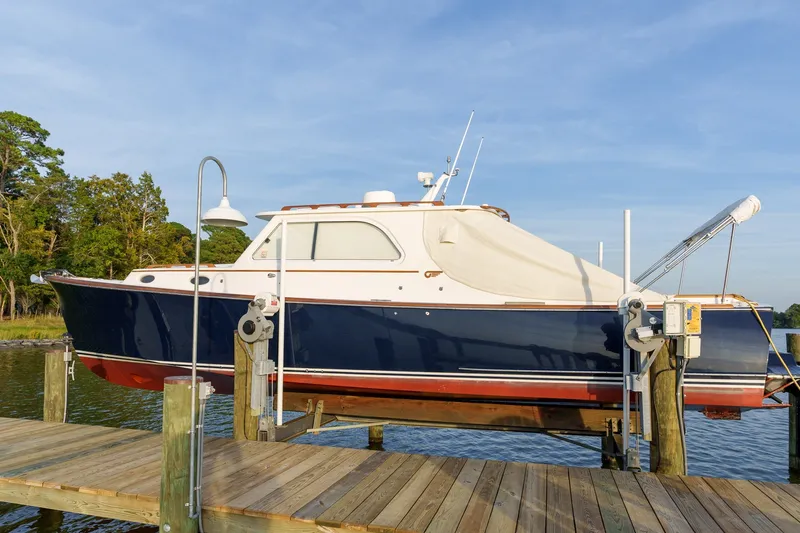 Slide: The Image of 2001 Hinckley Picnic Boat 36 EP on a dock lift, with scenic water backdrop. - 27