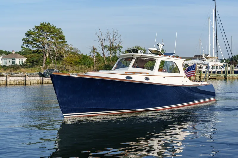 Slide: The Image of 2001 Hinckley Picnic Boat 36 EP cruising on calm waters near a marina. - 25