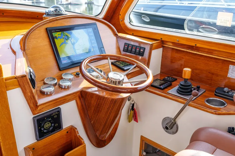 Slide: The Image of Helm of 2001 Hinckley Picnic Boat 36 EP with navigation screen and wooden steering wheel. - 13