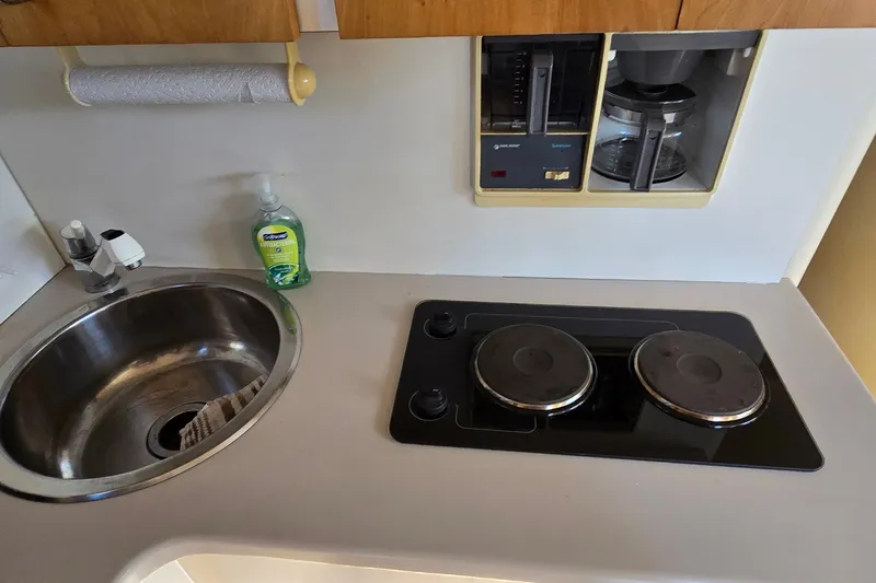 Slide: The Image of 1994 Mainship 40 Sedan Bridge kitchen with sink, stove, and coffee maker. - 22