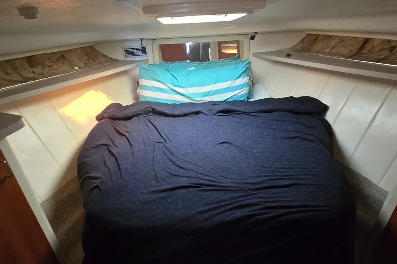 Slide: The Image of Cozy cabin interior of 1994 Mainship 40 Sedan Bridge with bed and striped pillows. - 24