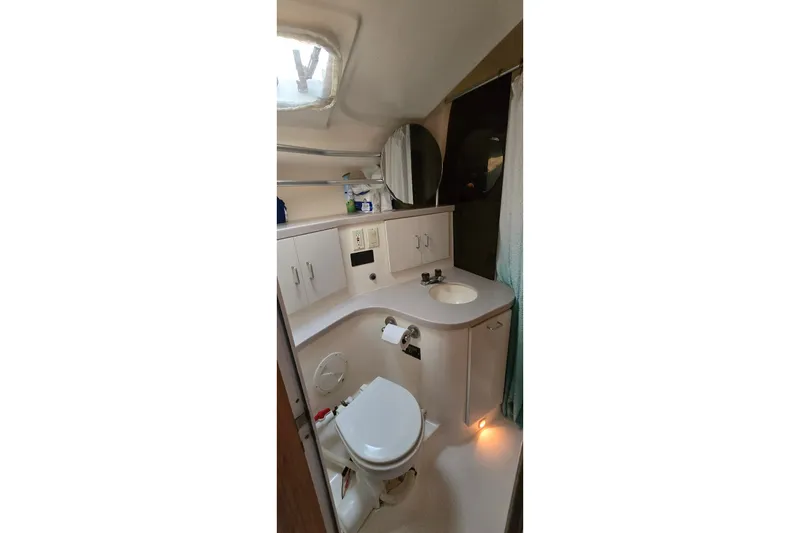 Slide: The Image of Bathroom interior of a 1994 Mainship 40 Sedan Bridge yacht, featuring sink and toilet. - 26