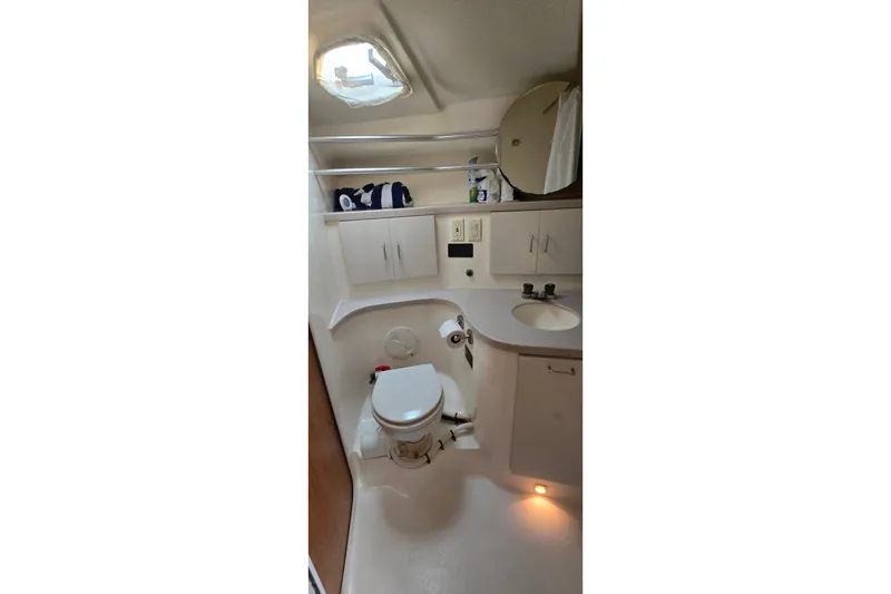 Slide: The Image of 1994 Mainship 40 Sedan Bridge bathroom with toilet, sink, and storage shelves. - 28
