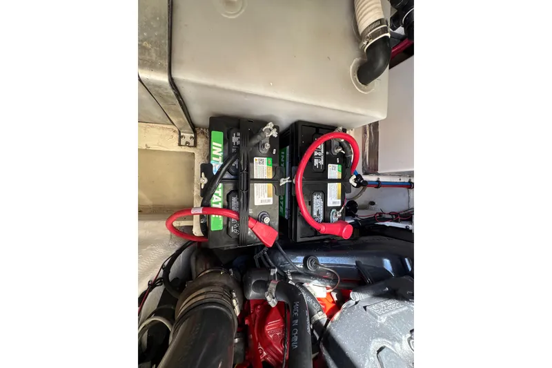 Slide: The Image of Battery compartment of a 2017 Regal 28 Express boat with connected cables. - 65