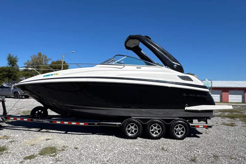 Slide: The Image of 2017 Regal 28 Express boat on trailer, parked outdoors under clear blue sky. - 2