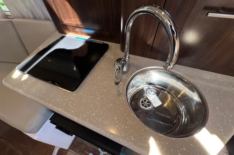 Slide: The Image of 2017 Regal 28 Express yacht interior with modern sink and stovetop. - 84