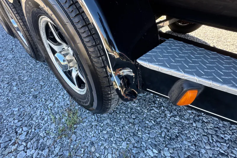 Slide: The Image of Trailer wheel and step of a 2017 Regal 28 Express on gravel surface. - 22
