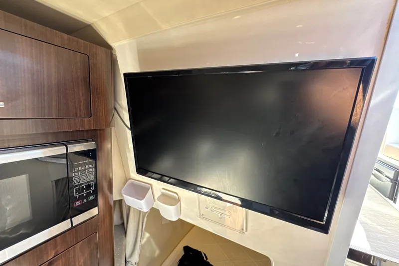 Slide: The Image of Interior of 2017 Regal 28 Express featuring a mounted TV and microwave. - 88