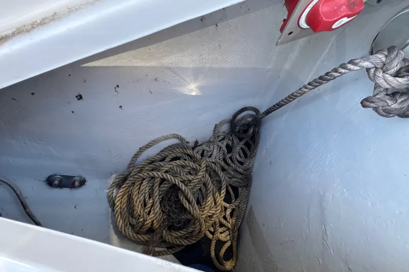 Slide: The Image of Storage compartment with coiled rope in a 2017 Regal 28 Express boat. - 54