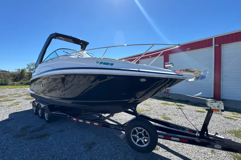Slide: The Image of 2017 Regal 28 Express boat on trailer, parked outdoors near storage units. - 18