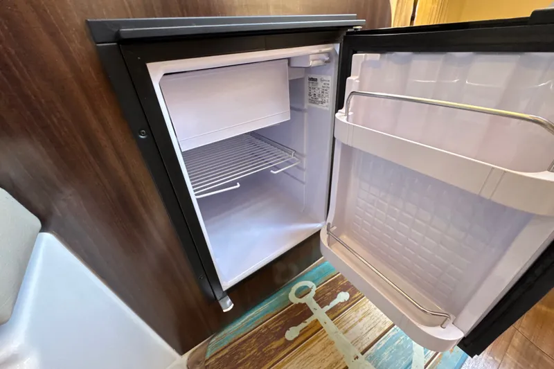 Slide: The Image of Open mini fridge inside 2017 Regal 28 Express boat cabin. - 90