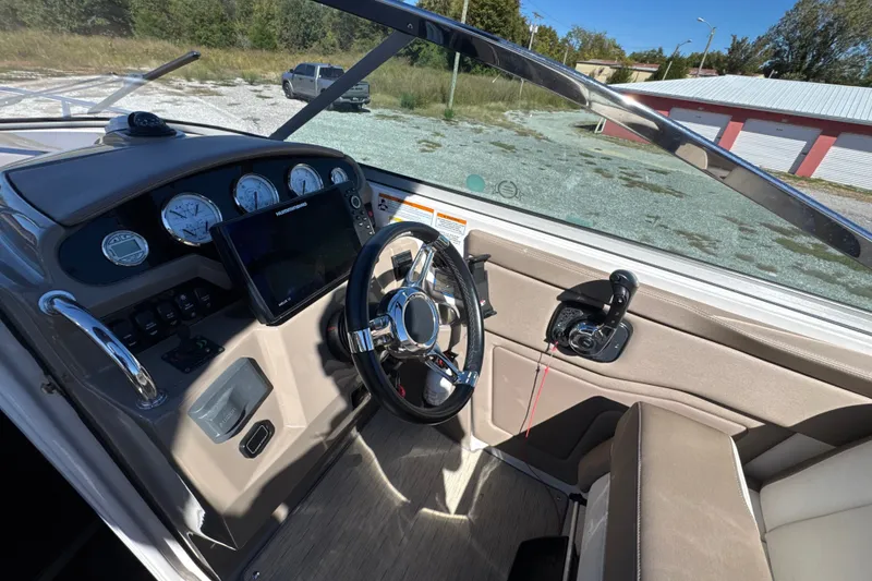 Slide: The Image of Cockpit of 2017 Regal 28 Express boat with steering wheel and control panel. - 75