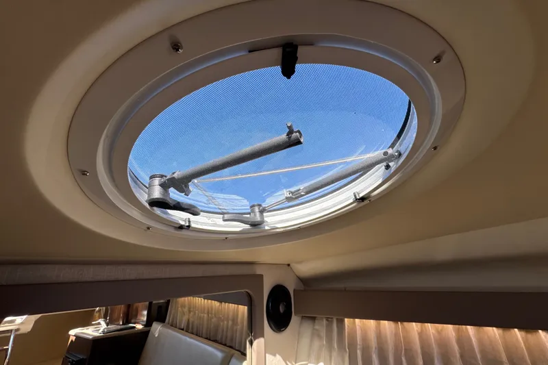 Slide: The Image of Interior view of 2017 Regal 28 Express boat's circular hatch with blue sky visible. - 96