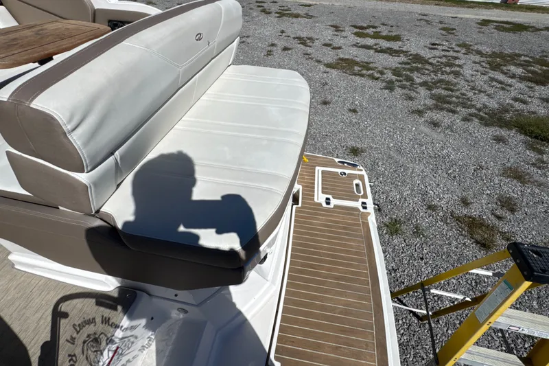Slide: The Image of 2017 Regal 28 Express boat interior with cushioned seating and wooden deck. - 24