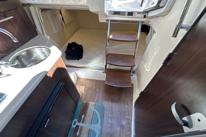 Slide: The Image of Interior of 2017 Regal 28 Express boat with kitchenette and cozy sleeping area. - 81