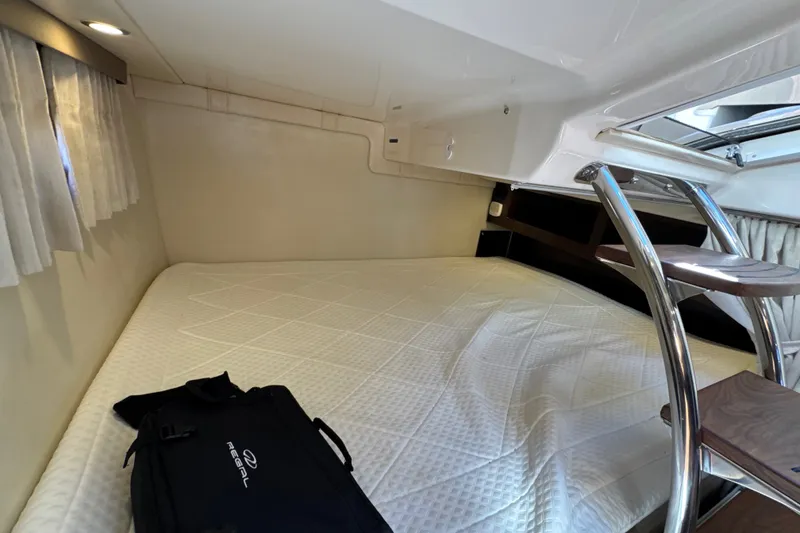 Slide: The Image of Cozy cabin interior of 2017 Regal 28 Express boat with bed and ladder. - 83