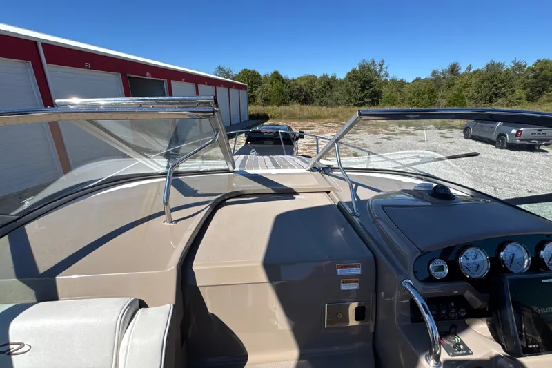 Slide: The Image of 2017 Regal 28 Express boat dashboard with gauges, windshield, and outdoor storage view. - 51