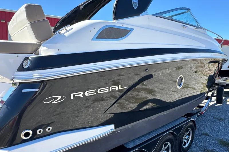 Slide: The Image of 2017 Regal 28 Express boat on trailer, black and white exterior, side view. - 17