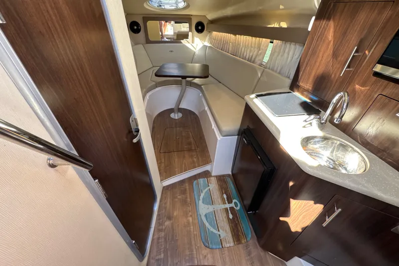 Slide: The Image of Interior of 2017 Regal 28 Express boat with kitchenette and seating area. - 77