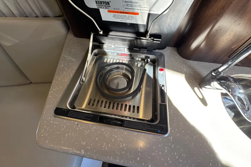 Slide: The Image of 2017 Regal 28 Express boat interior with Kenyon electric stove on countertop. - 85