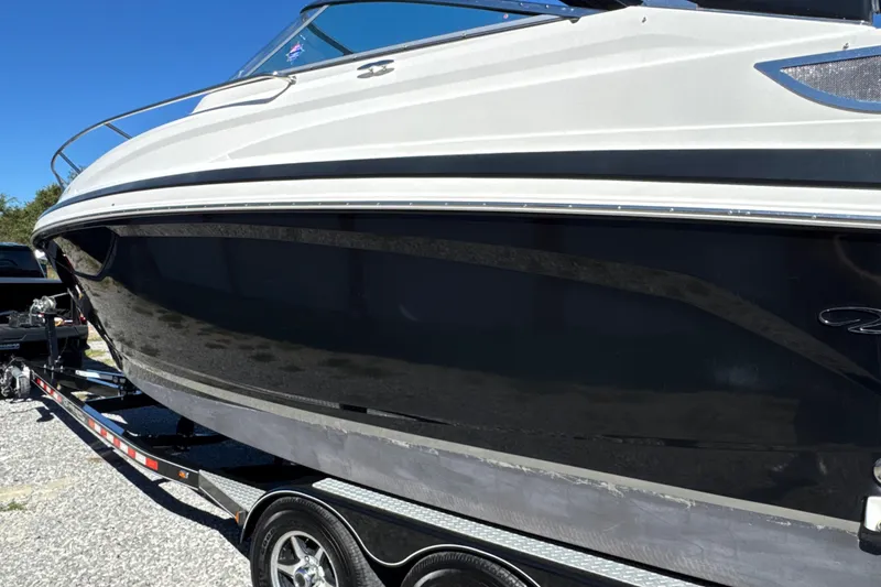 Slide: The Image of 2017 Regal 28 Express boat on trailer, sleek black hull, sunny day. - 4