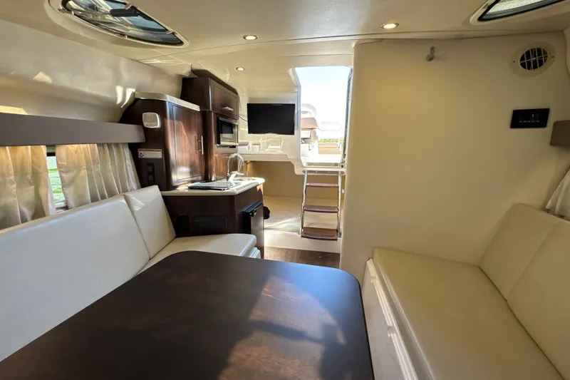 Slide: The Image of Interior of 2017 Regal 28 Express boat with kitchenette, seating, and modern amenities. - 94