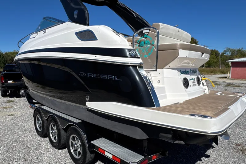 Slide: The Image of 2017 Regal 28 Express boat on trailer, sleek design, black and white exterior. - 5