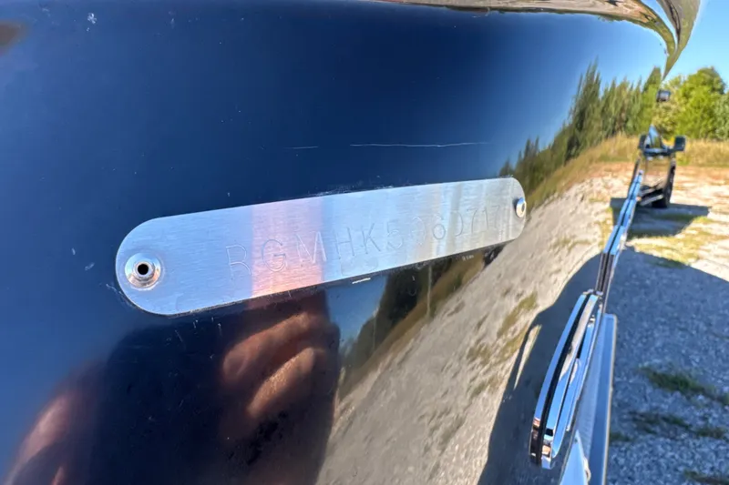 Slide: The Image of 2017 Regal 28 Express boat with identification plate in a sunny outdoor setting. - 15