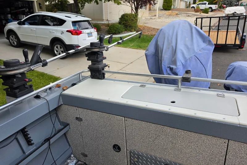 Slide: The Image of Fishing boat setup with rod holders, Raider 190 Explorer, parked in a residential driveway. - 3