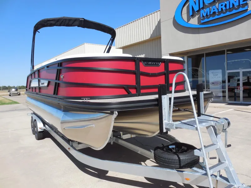 Slide: The Image of A red Evotti 525CSA pontoon boat from 2027 on a trailer in front of a building. - 3