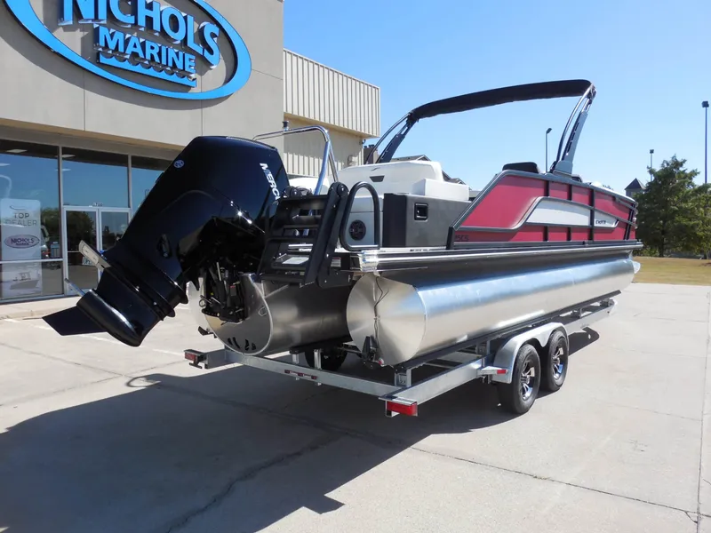 The Image of A 2027 Evotti 525CSA pontoon boat on a trailer outside a building with a "Nichols Marine" sign. - 0