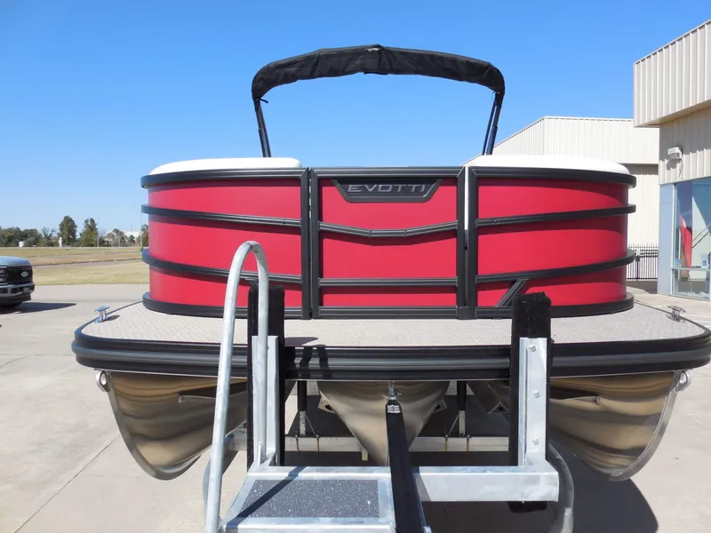 Slide: The Image of A red Evotti 525CSA pontoon boat from 2027 is on a trailer in an outdoor setting. - 9