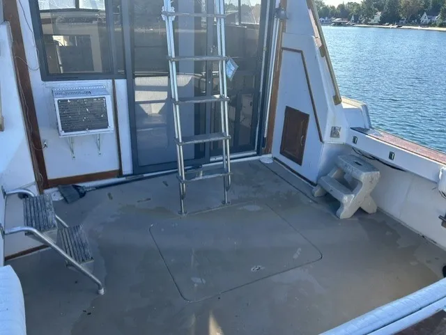 Slide: The Image of The image shows the aft deck of a 1979 Mainship 34 Trawler with a ladder and seating. - 5