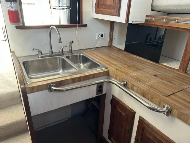 Slide: The Image of The galley of a 1979 Mainship 34 Trawler with a double sink and wooden countertop. - 15