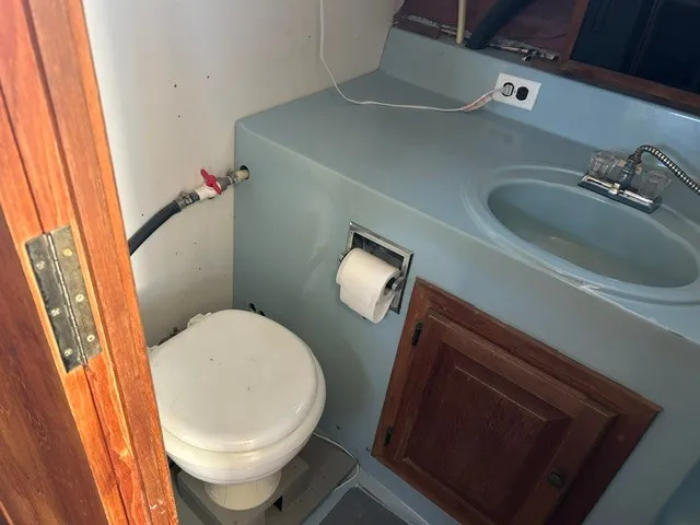 Slide: The Image of The image shows a boat bathroom with a toilet, sink, and wooden cabinet. - 18
