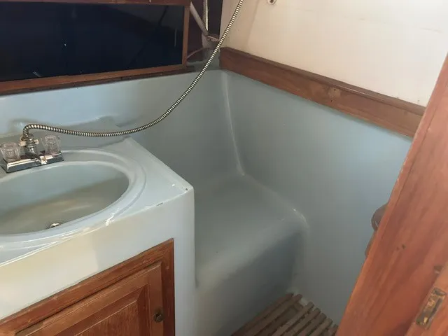 Slide: The Image of The image shows a boat bathroom with a sink, faucet, and wooden accents. - 19