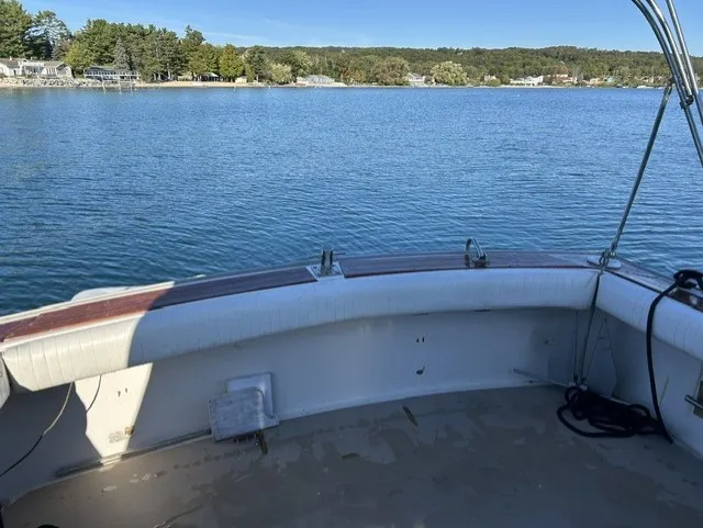 Slide: The Image of The image shows the stern of a 1979 Mainship 34 Trawler on calm water. - 7