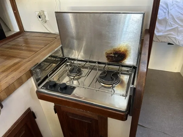 Slide: The Image of A galley area with a two-burner gas stove and wooden countertops on a boat. - 17