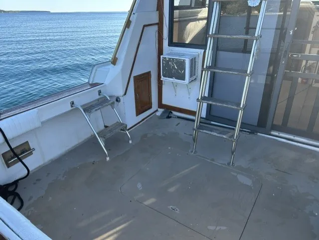 Slide: The Image of The image shows the deck of a 1979 Mainship 34 Trawler with a ladder and a window. - 6